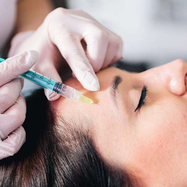 Injectable tissue stimulator on woman face in beauty salon. Aesthetic medicine